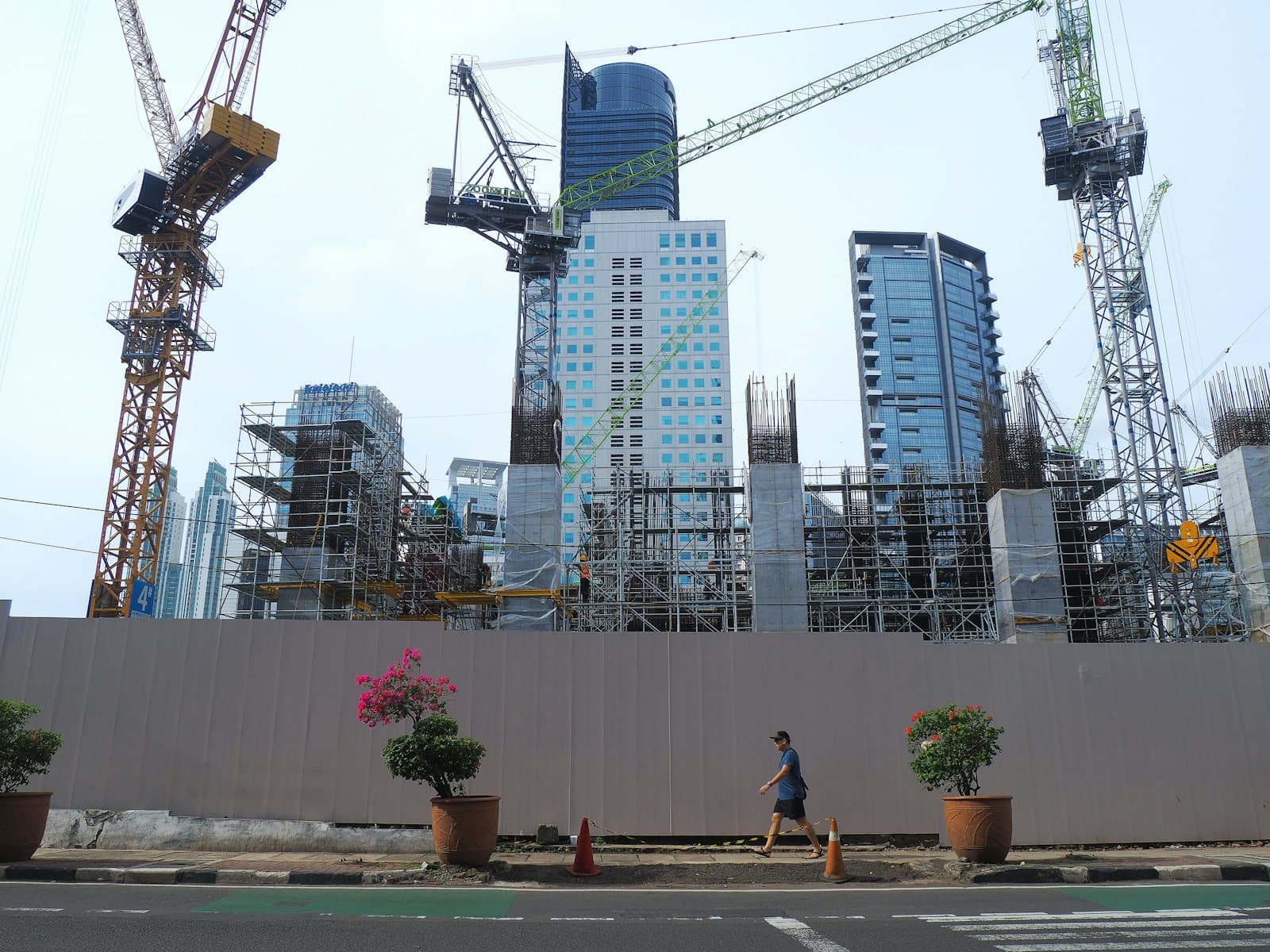 Wide view of a mixed-use development site with several tower cranes