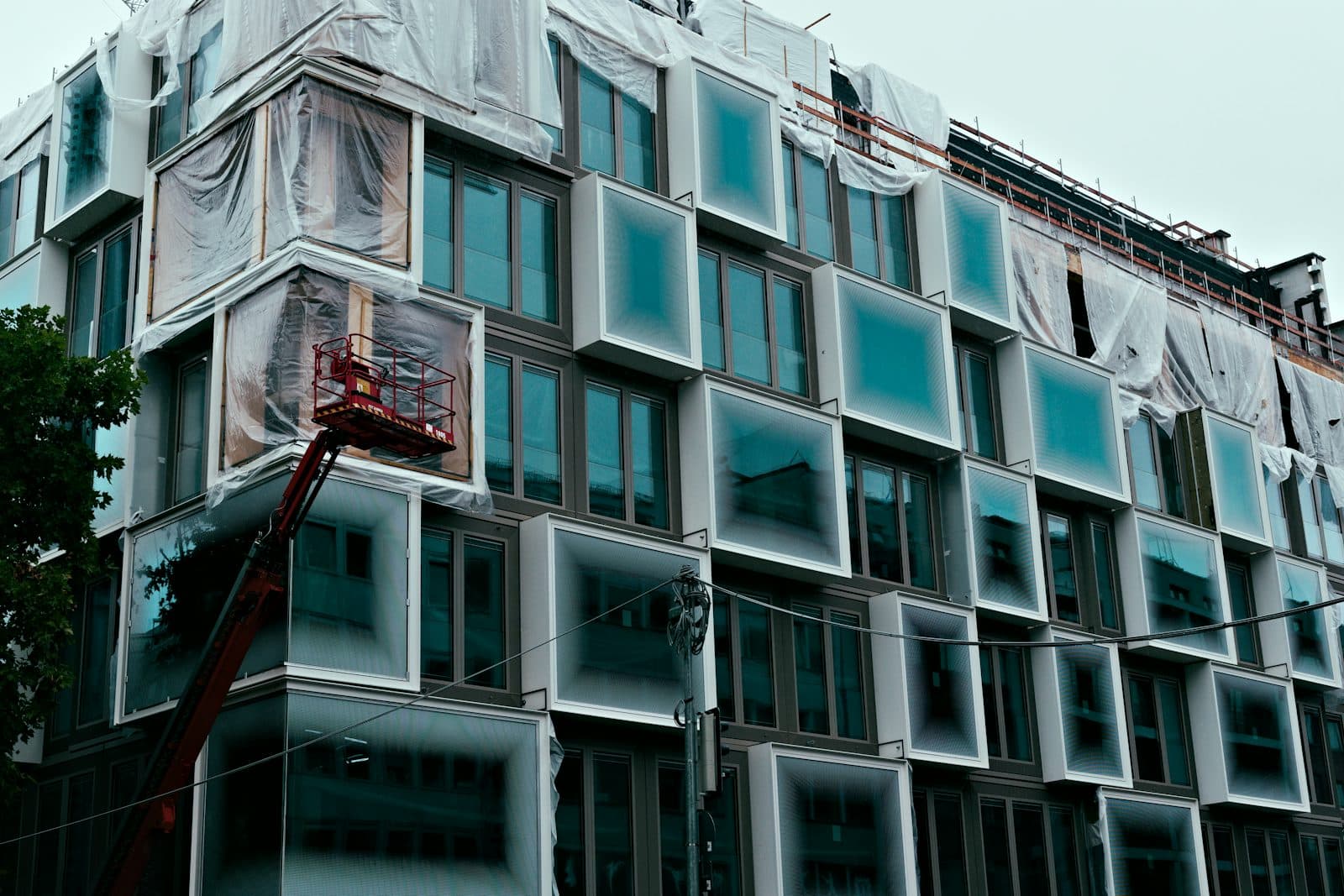 Glass curtain wall panels being installed on a tower