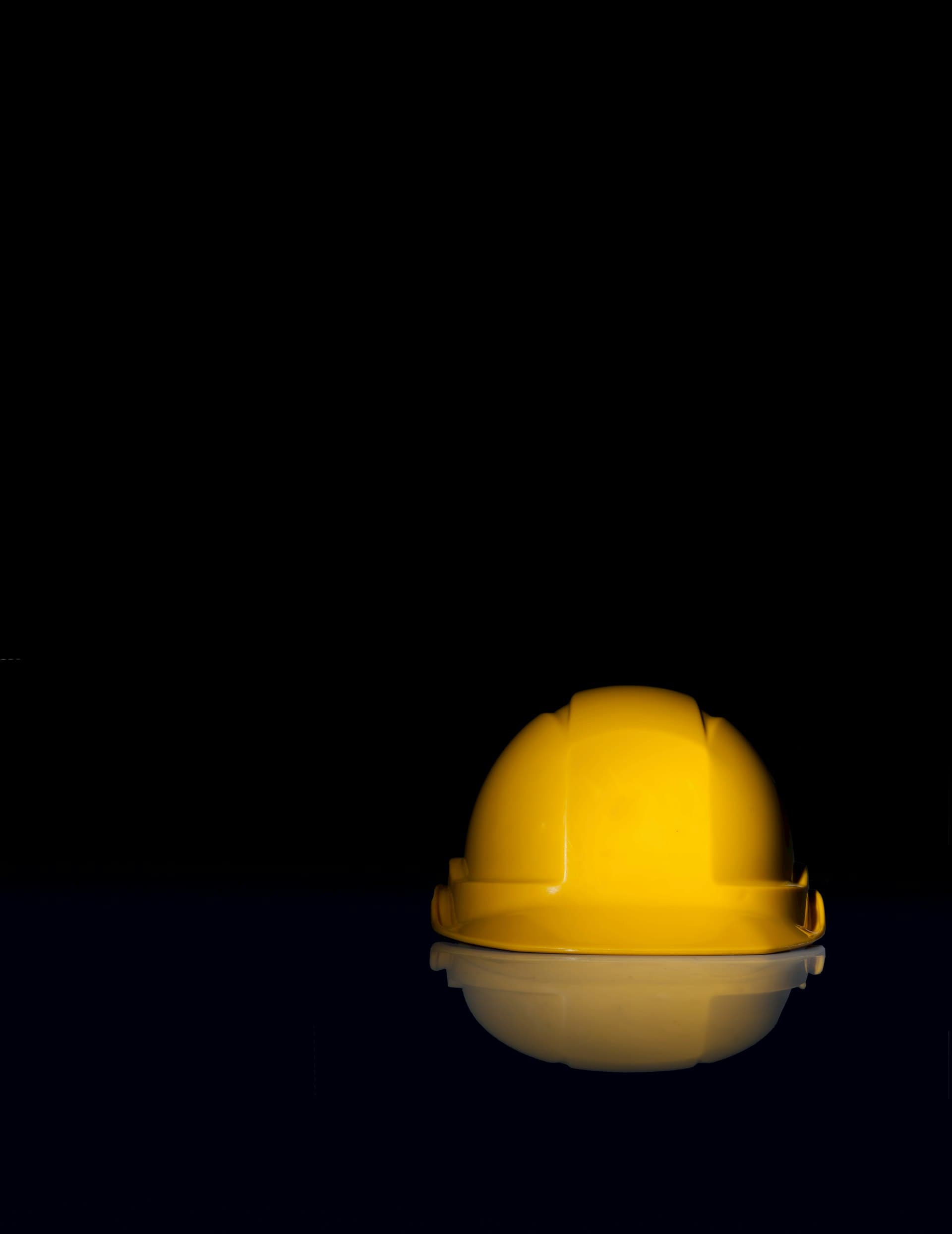 A single hard hat lit against a black background