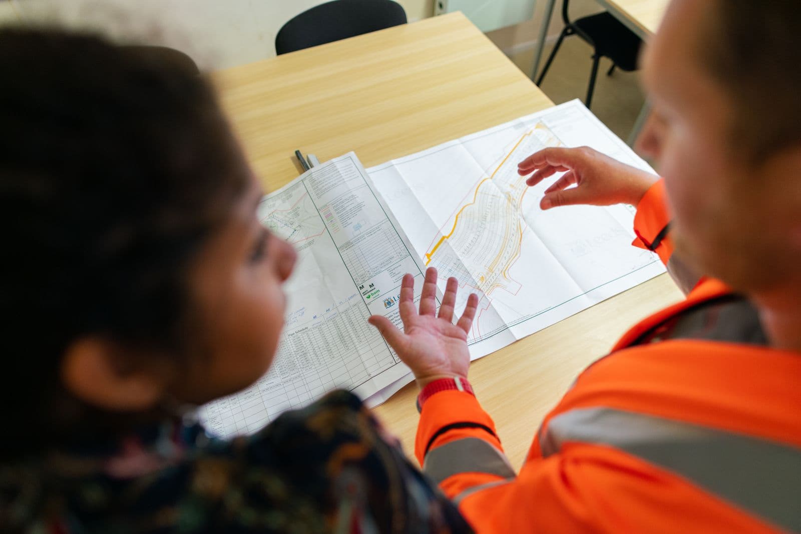 Engineer reviewing plans at a site office table