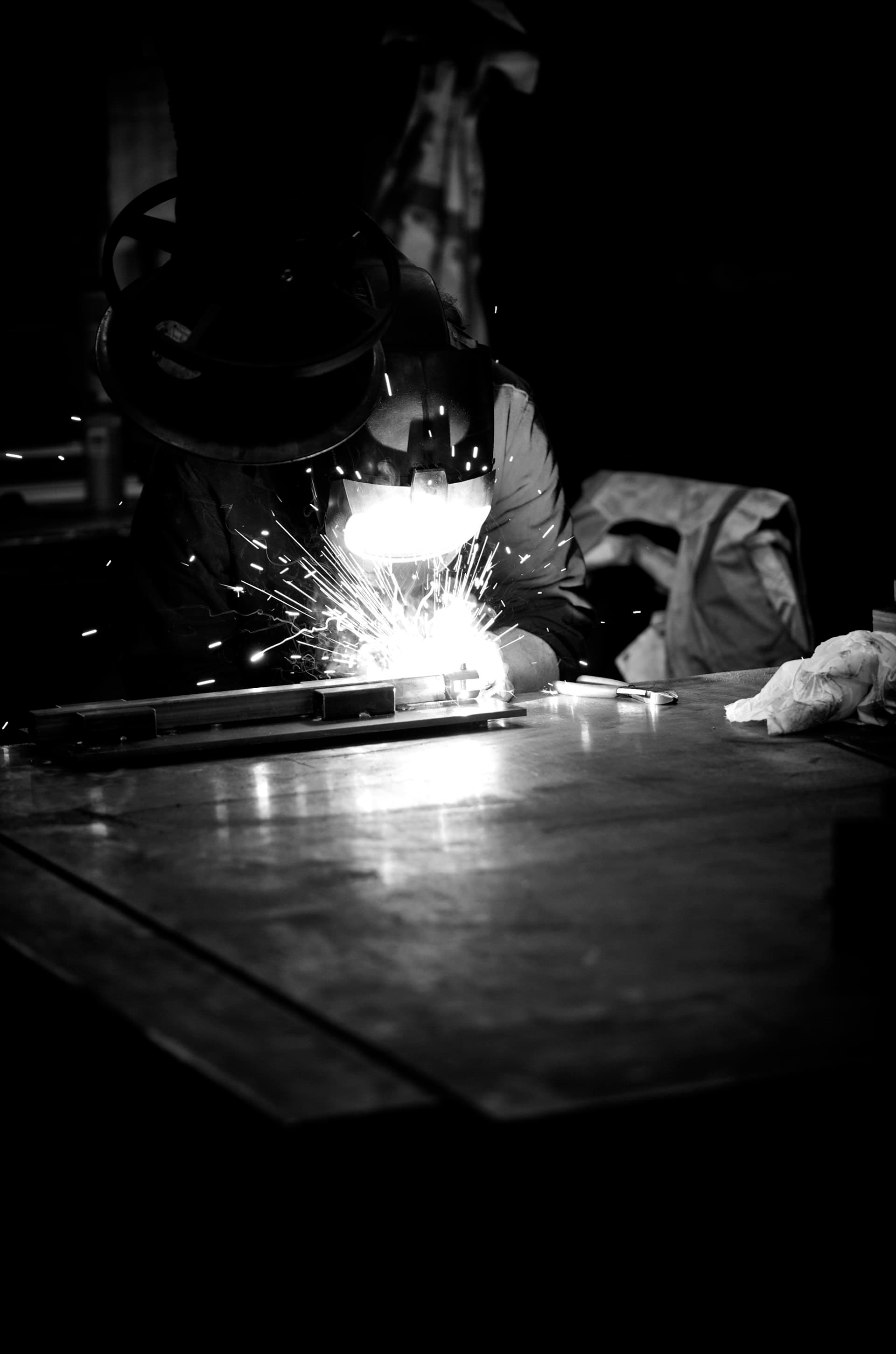 Welder joining steel, sparks around the arc